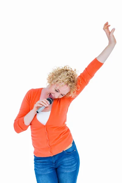 Šťastné blond zpěv v mikrofonu — Stock fotografie