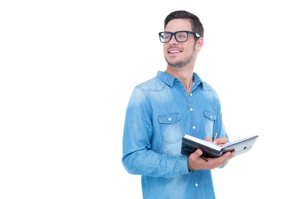 Geeky hipster taking notes in book — Stock Photo, Image