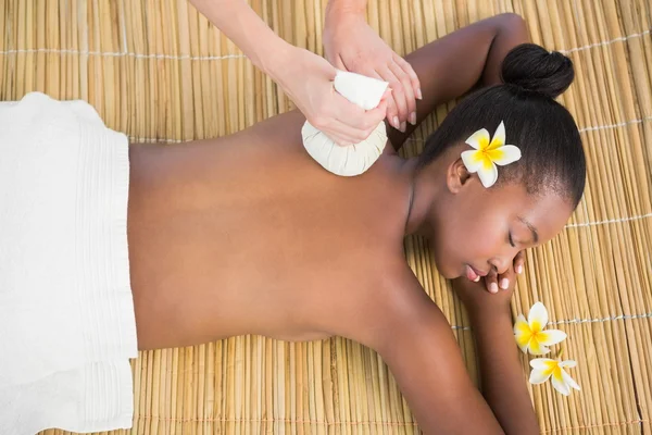 Mujer disfrutando de masaje de compresa a base de hierbas — Foto de Stock