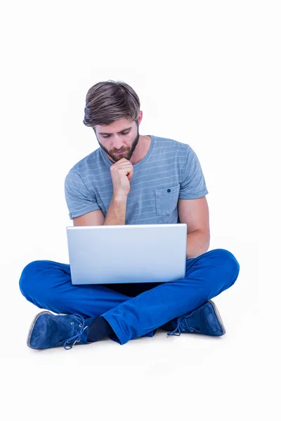 Schöner Mann, der hinter seinem Laptop denkt — Stockfoto