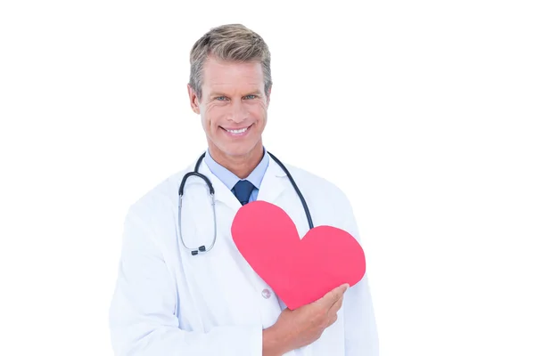 Smiling doctor holding heart card — Stock Photo, Image