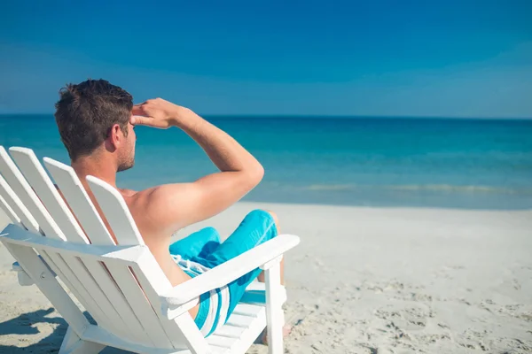 Homem relaxante na cadeira deck na praia — Fotografia de Stock