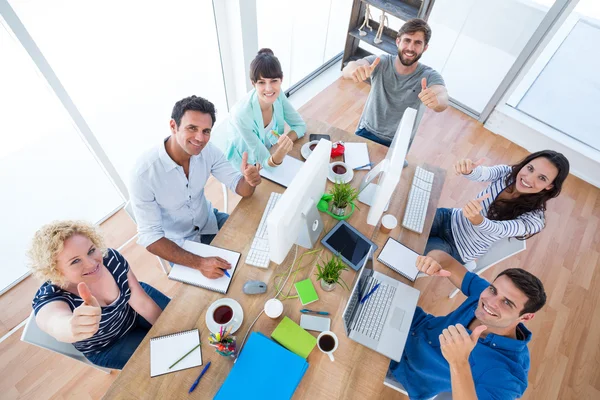 Equipe de negócios criativa gesticulando polegares em uma reunião — Fotografia de Stock