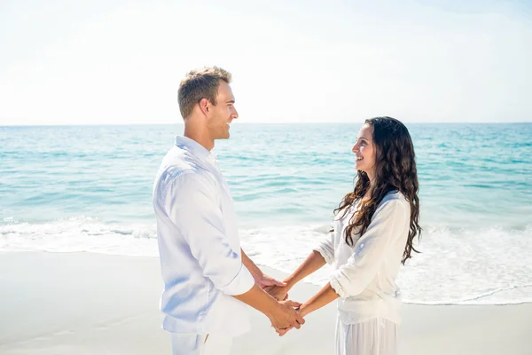 Paar, houdend handen en permanent op strand — Stockfoto