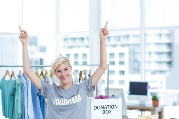 Glad blondin volontär pekar uppåt — Stockfoto