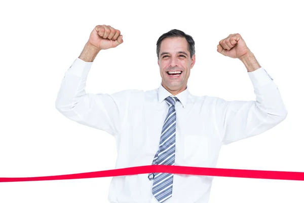 Happy businessman cutting red ribbon — Stock Photo, Image