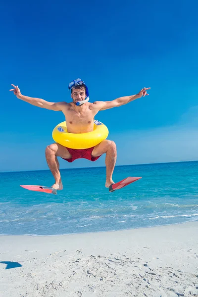 Homem usando nadadeiras e anel de borracha na praia — Fotografia de Stock