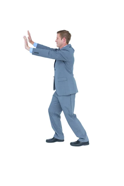 Businessman standing and pushing with hands — Stock Photo, Image
