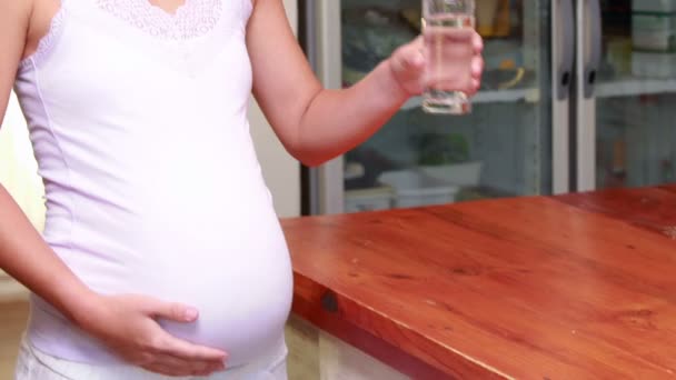 Беременная женщина пьет стакан воды — стоковое видео