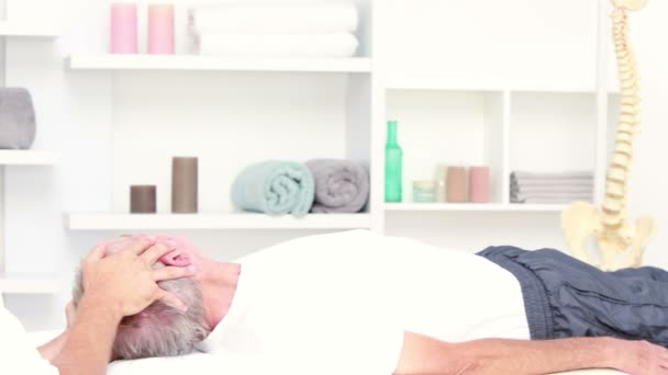 Fysiotherapeut stretching zijn patiënt hoofd — Stockvideo
