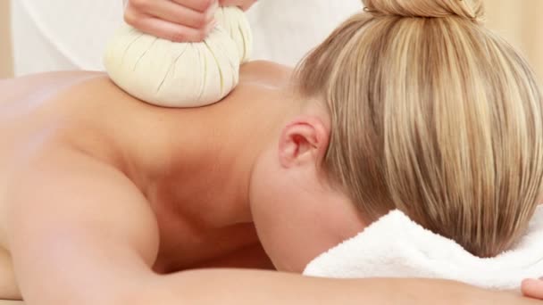 Kvinna som njuter av en växtbaserade komprimerar massage — Stockvideo