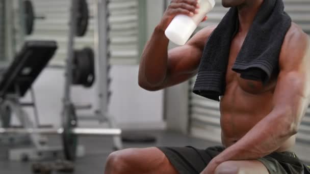 Hombre bebiendo batido de proteínas en el gimnasio — Vídeo de stock