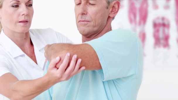 Doctor estirando su brazo paciente — Vídeo de stock