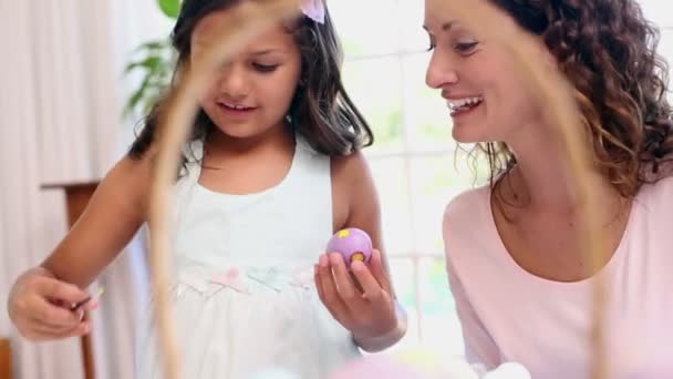 Мать и дочь рисуют пасхальные яйца — стоковое видео