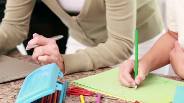 Madre utilizzando il computer portatile e suo figlia disegno — Video Stock