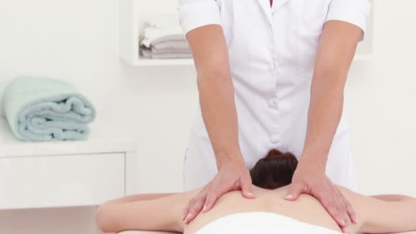Физиотерапевт делает массаж спины пациентке — стоковое видео