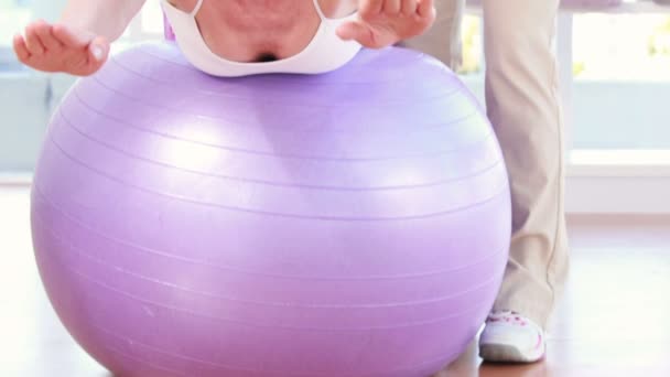 Trainer with woman on exercise ball — Stock Video