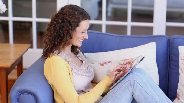 Mujer feliz usando la tableta en el sofá — Vídeos de Stock