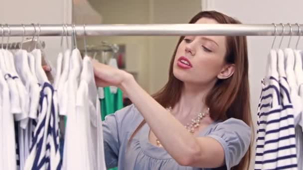 Frau beim Einkaufen im Bekleidungsgeschäft — Stockvideo