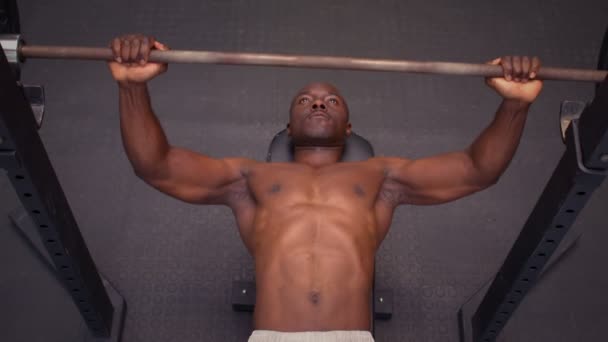 Hombre sosteniendo la barra acostado en la alfombra de ejercicio — Vídeo de stock