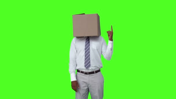 Бизнесмен с коробкой над головой и указанием — стоковое видео