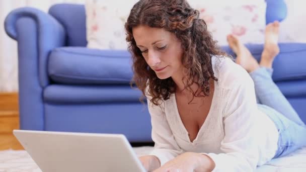 Щаслива жінка використовує ноутбук на килимку — стокове відео
