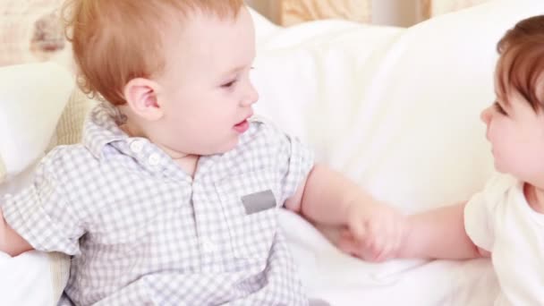 Schattige baby's op een bed — Stockvideo