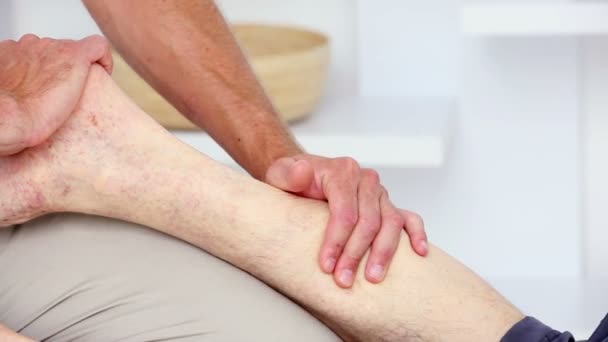 Médico massageando seus pacientes bezerro — Vídeo de Stock
