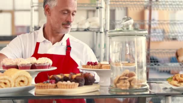 Server with thumbs up behind cakes — Stock Video