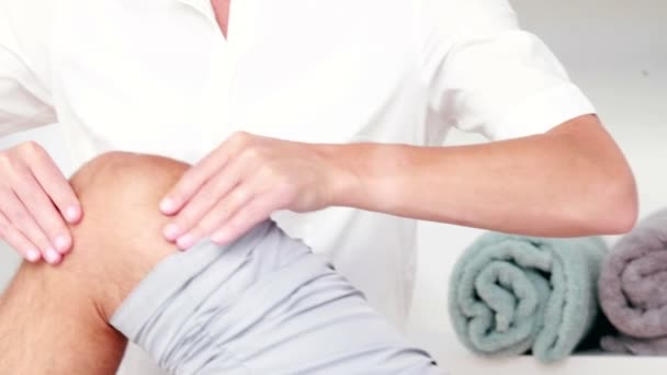 Fisioterapeuta haciendo masaje de rodilla a su paciente — Vídeos de Stock