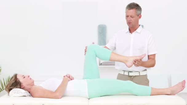 Physiotherapeut streckt seinem Patienten die Beine — Stockvideo