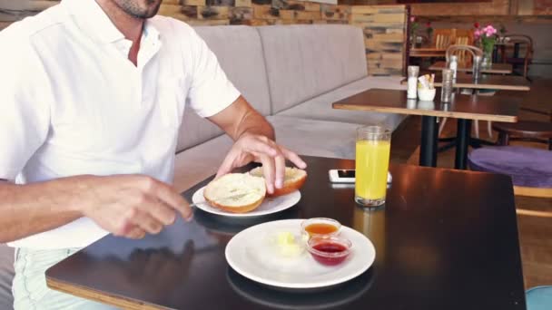 Hombre mantecando su pan — Vídeo de stock