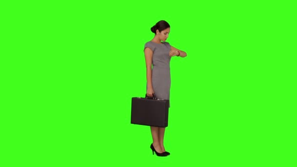 Affärskvinna stående kontrollera tiden — Stockvideo