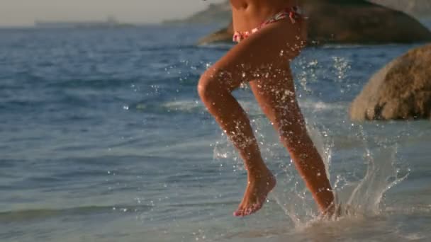 Woman running on the beach with an umbrella — Stock Video