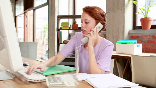 Mujer de negocios casual en el teléfono en su escritorio — Vídeo de stock