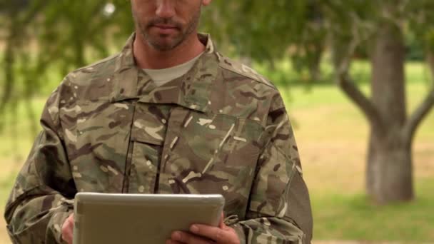 Soldado mirando tableta PC en el parque — Vídeo de stock