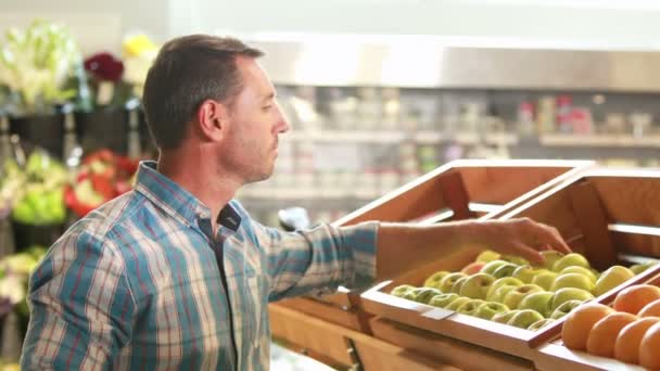 Hombre recogiendo fruta en el supermercado — Vídeo de stock