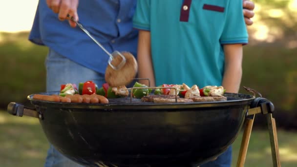 Glücklicher Vater beim Grillen mit seinem Sohn — Stockvideo