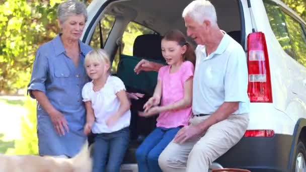 Familie zittend op auto boot — Stockvideo