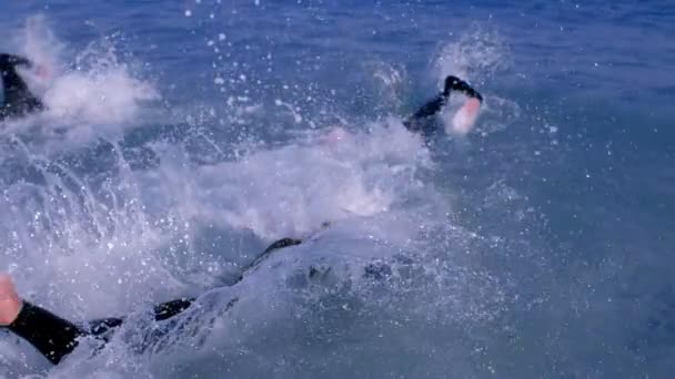 Drie atletische surfers duiken in de zee — Stockvideo