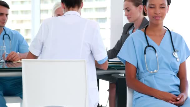 Médico feliz com seus colegas por trás — Vídeo de Stock