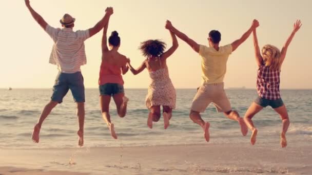 Skupina přátel, skáčou dohromady na pláži — Stock video