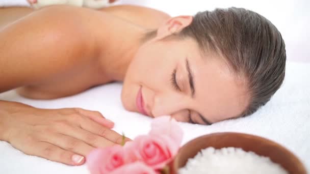 Woman enjoying a herbal compress massage — Stock Video
