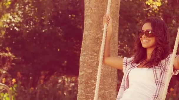 Půvabná brunetka dělá houpačka v parku — Stock video