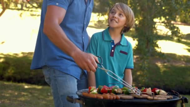 Padre haciendo barbacoa con su hijo — Vídeo de stock