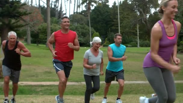Счастливая спортивная группа, бегающая в парке — стоковое видео