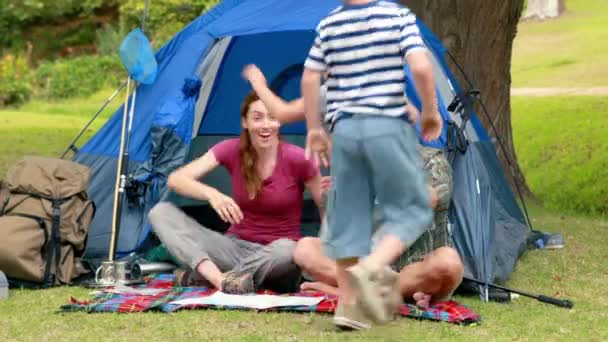 Família em uma viagem de acampamento na frente de sua tenda — Vídeo de Stock