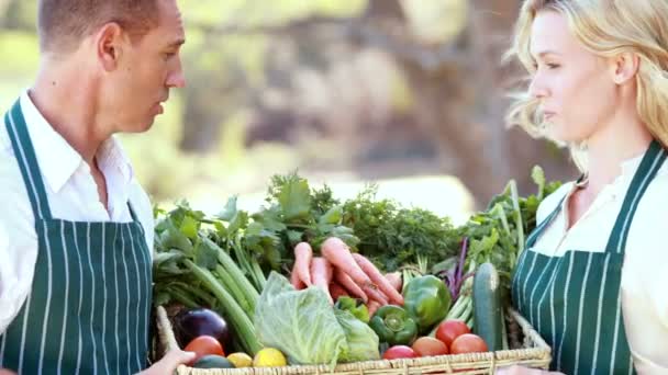 Фермерская пара держит корзину с овощами — стоковое видео