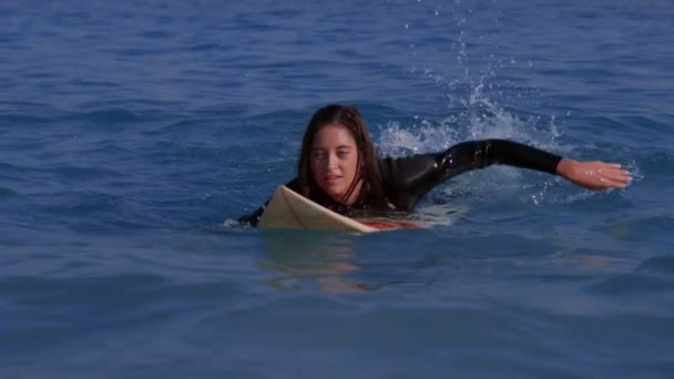 Mujer bonita remando en una tabla de surf — Vídeo de stock