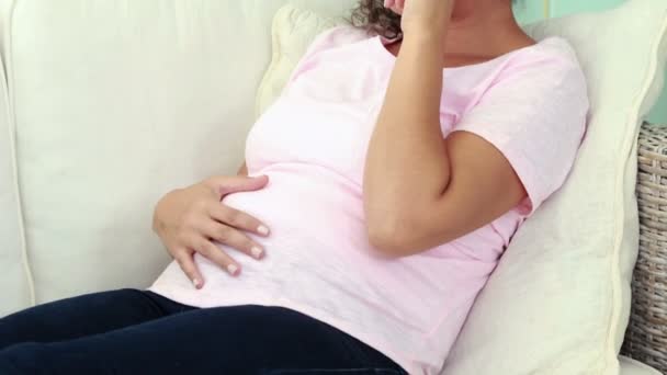 Беременная женщина плачет на диване — стоковое видео